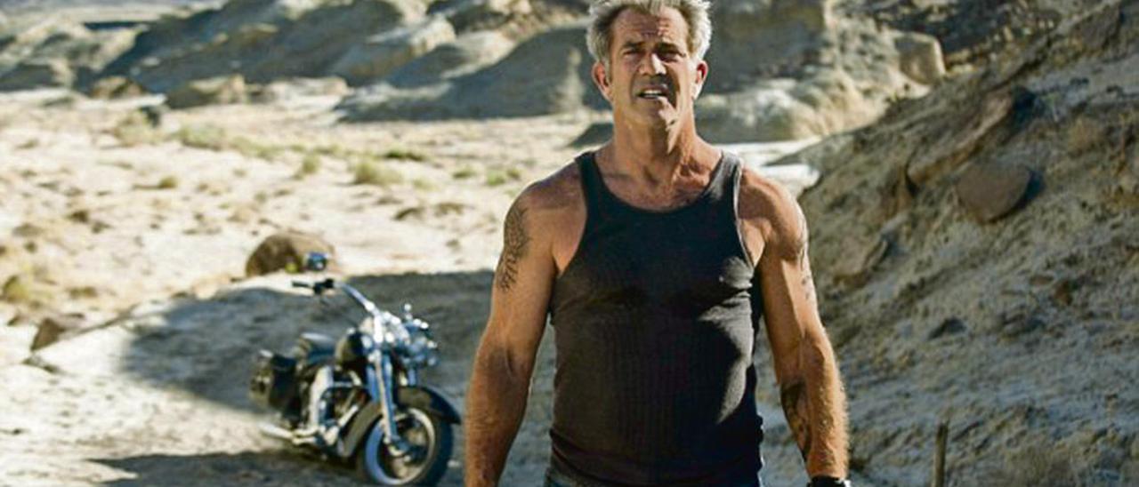 Mel Gibson, y su moto detrás.