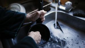 Una persona lava platos en un fregadero.