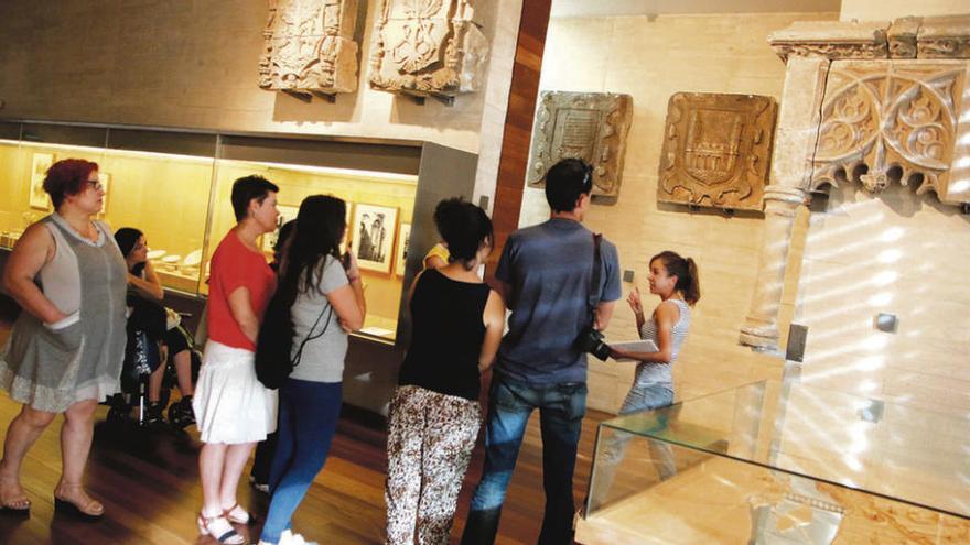 Los espectadores atienden a las explicaciones de la guía del Museo.