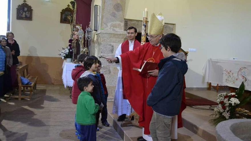 El obispo de Astorga, Juan Antonio Menéndez, bendice a los niños en Ferreras de Arriba.