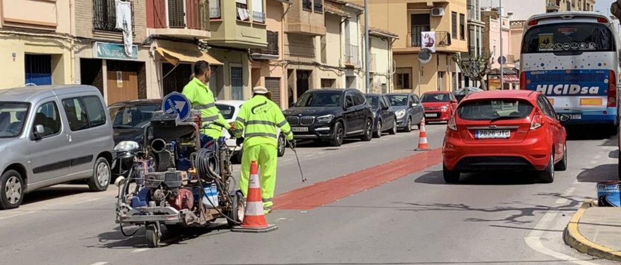 Operarios durante los trabajos de pintado de la mediana central en Nules. | MIRA