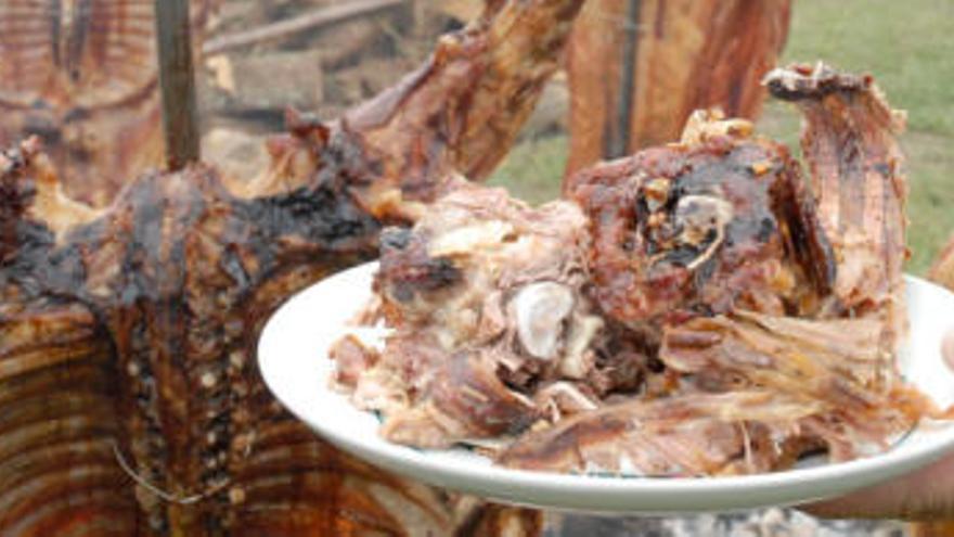 Un romero sujeta su plato frente a la corderada del Prau Llagüezos.