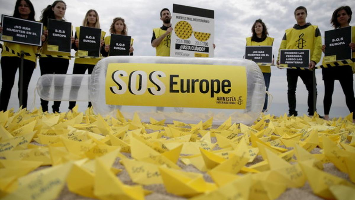 Activistas de Amnistía Internacional denuncian en la playa de Sant Sebastià de Barcelona las muertes de migrantes en el Mediterráneo