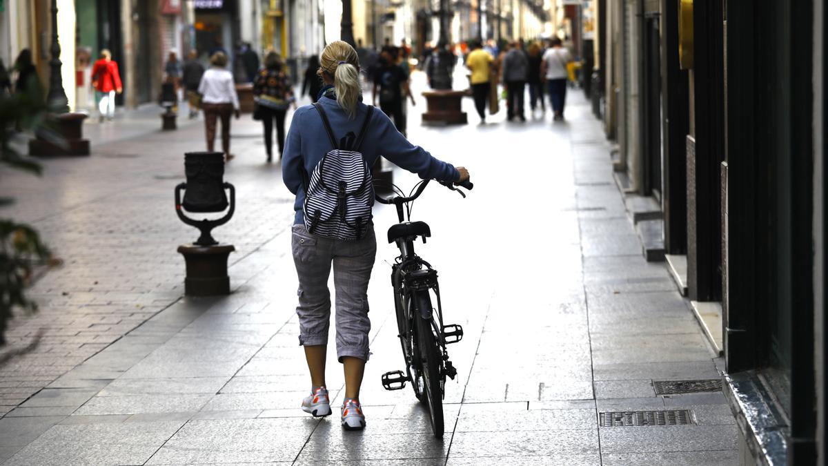 Una ciclista cruza andando la calle Alfonso, por donde está prohibido circular.