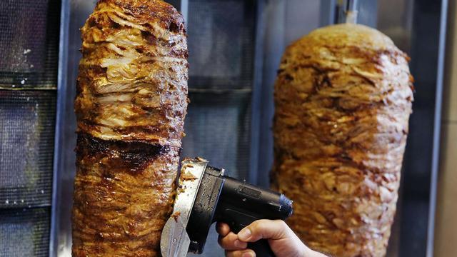 Un hombre corta carne de kebab en un establecimiento de Fráncfort.