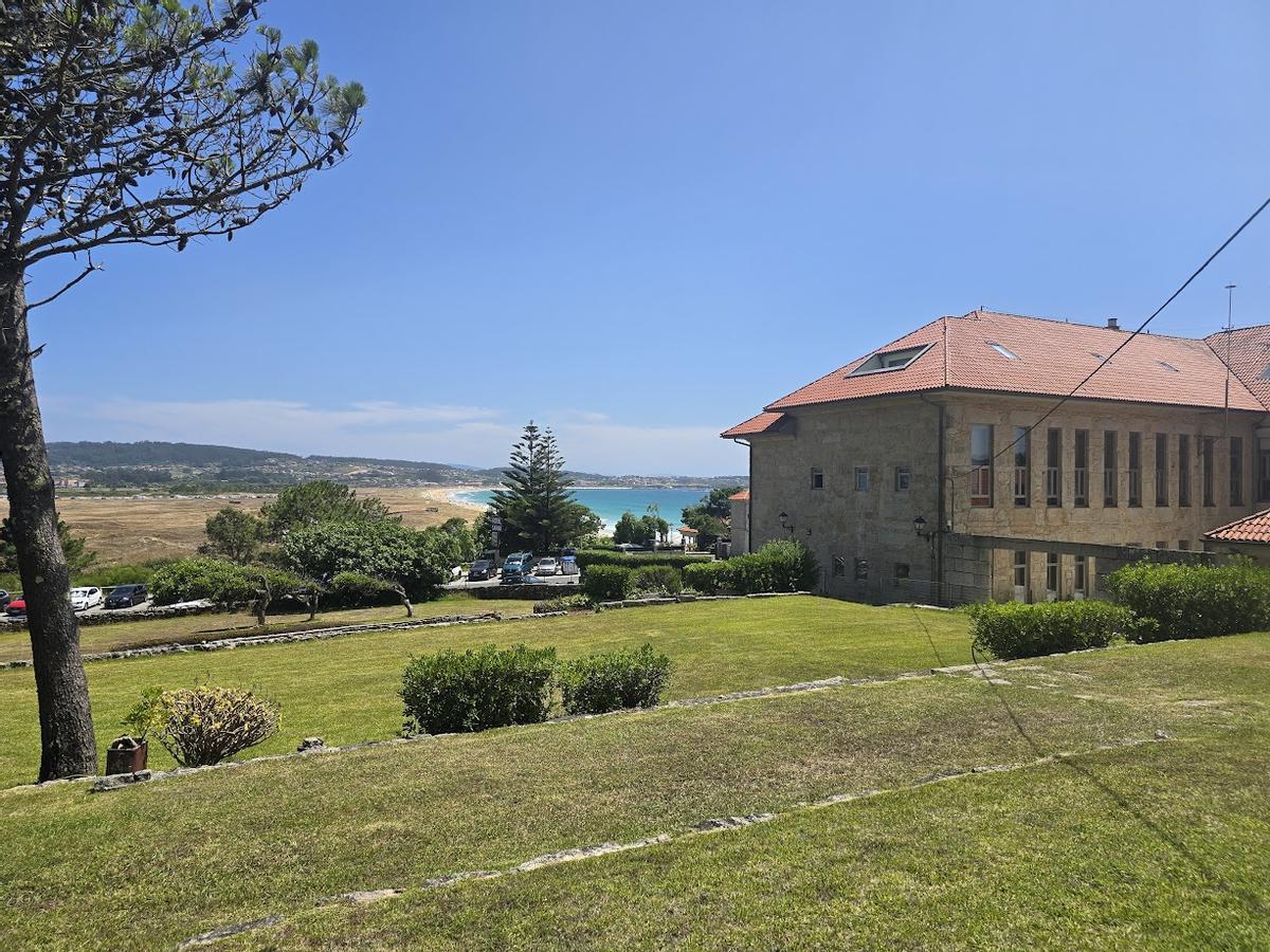 El edificio del antiguo sanatorio, ahora Pouasda da Lanzada, con la playa al fondo.