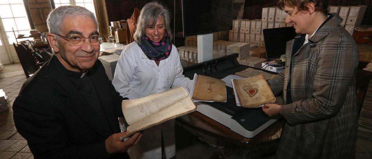 Sobre estas líneas, Avelino Bouzón, canónigo archivero de la catedral de Tui; Macarena Cuíñas, auxiliar del Archivo; y Lidia Ferrer, responsable del proyecto de digitalización. | // ANXO GUTIÉRREZ