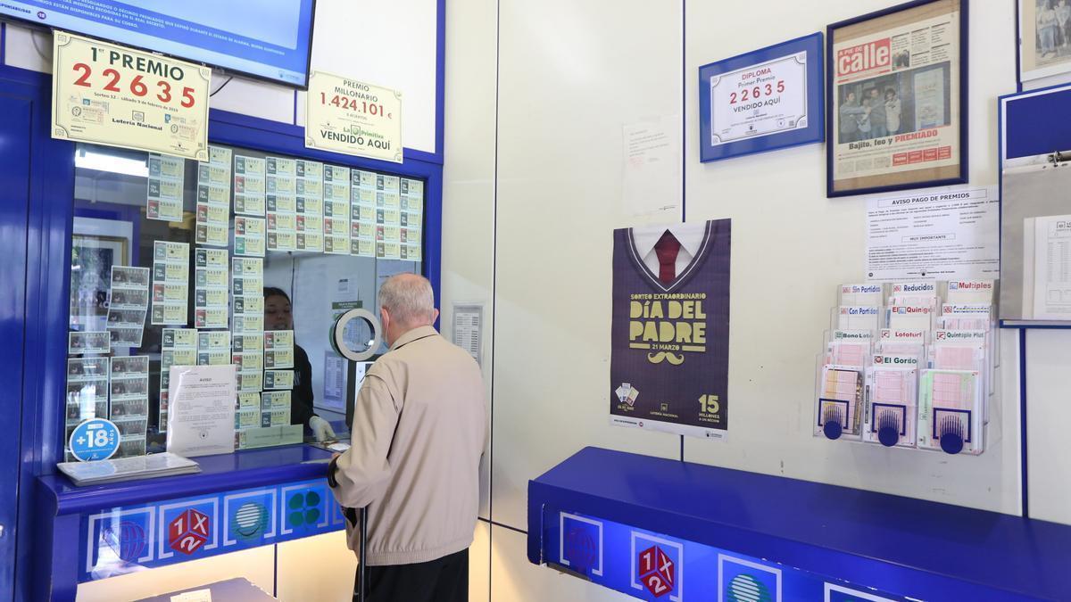 Archivo - Un hombre compra lotería en una Administración de Lotería.