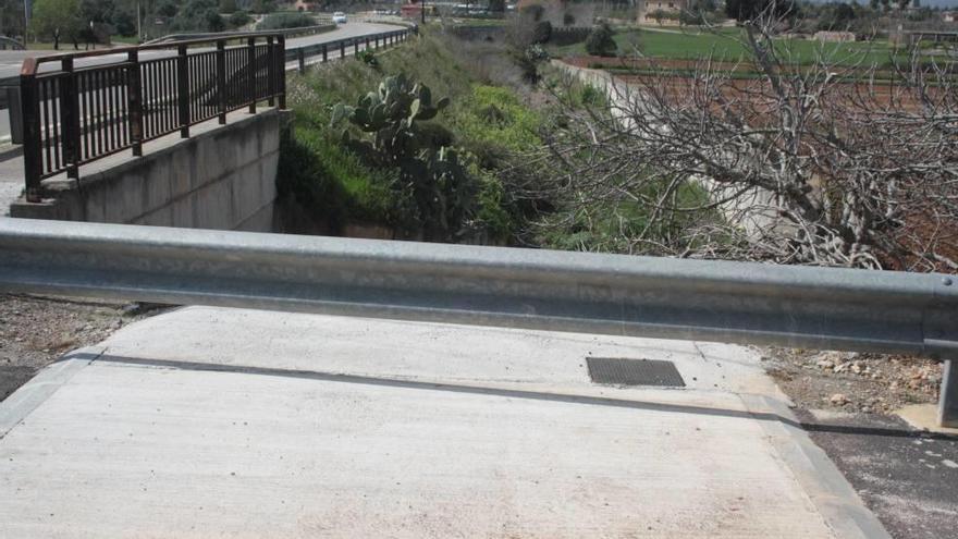 En la imagen se observa cómo el paseo peatonal finaliza de forma brusca ante el torrente sin otra opción que seguir por la carretera.