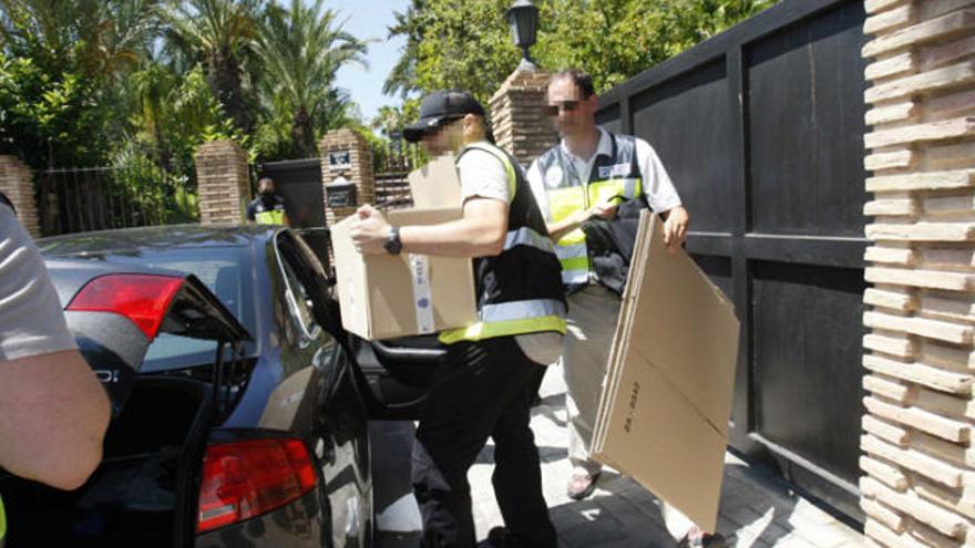 La Policía sale del chalé de Ortiz con cajas con el material intervenido.