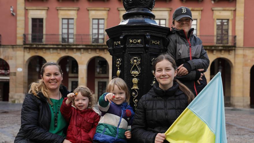 La joven Noema Sheprykevych, sentada a la derecha, en la plaza del Ayuntamiento de Gijón, con su madre, Liliia, y sus hermanos Ruvim y los gemelos Daniel y Manuel. | Juan Plaza