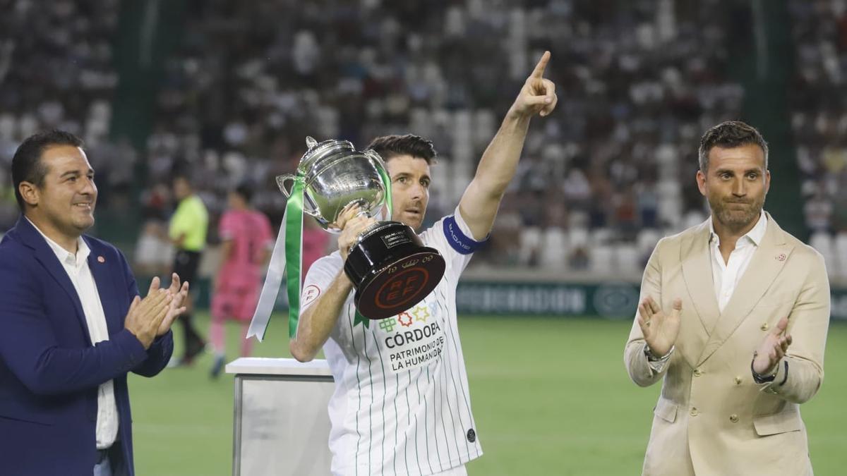 Javi Flores, en el centro de la imagen, dedica el trofeo por el campeonato de Segunda RFEF a la afición.