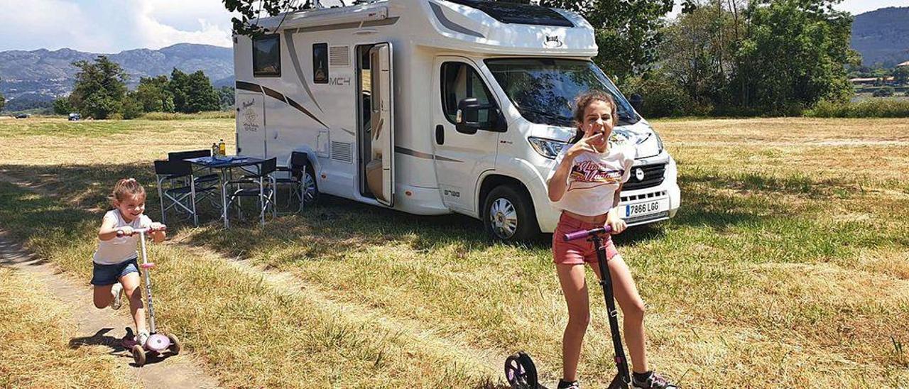 Dos niñas juegan ante la autocaravana aparcada en un campo de la provincia de Pontevedra.