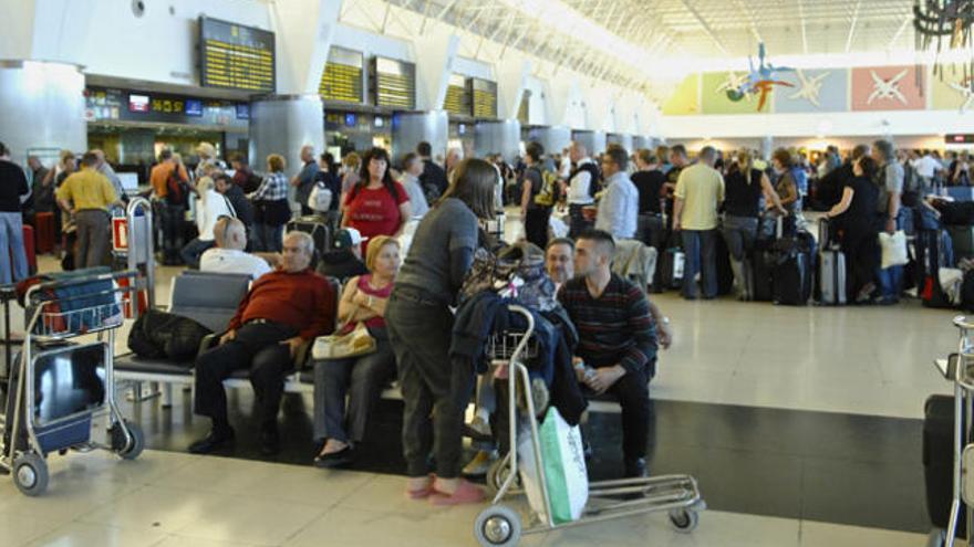 Pasajeros ante los puestos de facturación en el aeropuerto de Gando. | andrés cruz