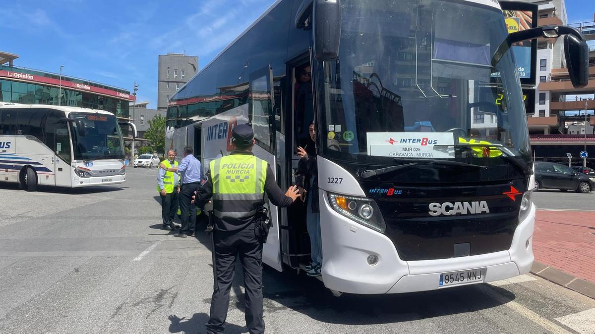 Un agente de Policía Local junto al autobús implicado en el suceso.