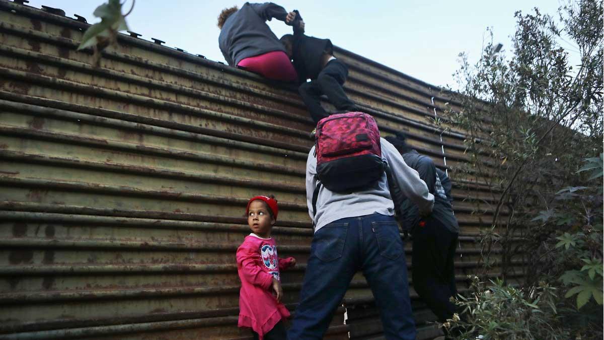 Una familia de migrantes trata de cruzar la frontera en Tijuana.