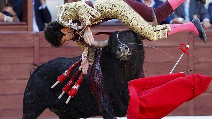 la derecha, el torero, con las dos orejas del astado.