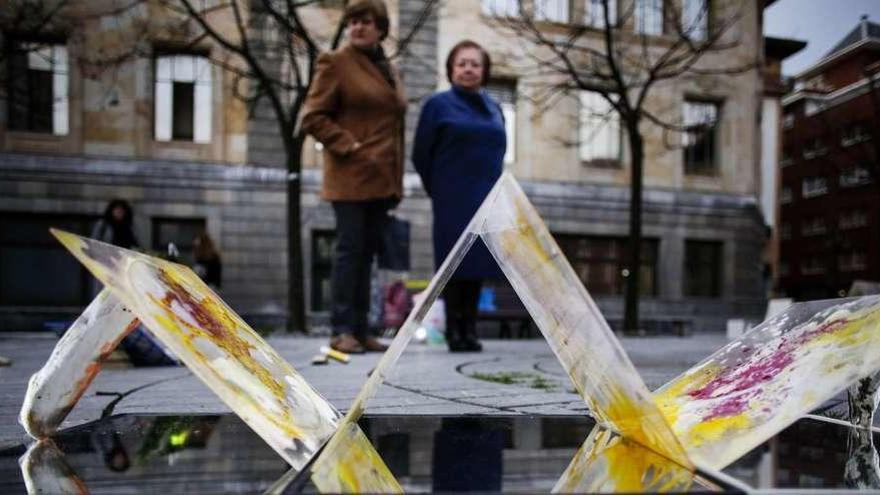 Dos mujeres contemplan las obras del proyecto &quot;Luciérnaga&quot;, en la plaza de Porlier; en primer término una obra de Yolanda Vivero.