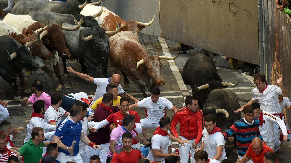 Los mozos corren ante los toros de la ganadería de José Escolar durante el tercer del encierro de San Fermín.