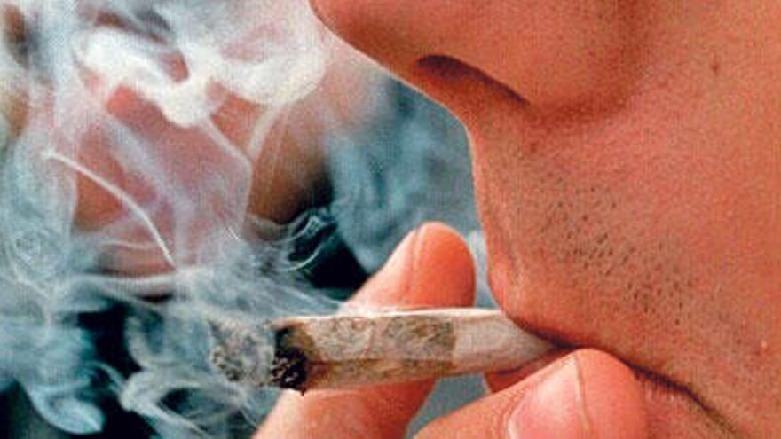 Un joven consume un cigarrillo de cannabis.