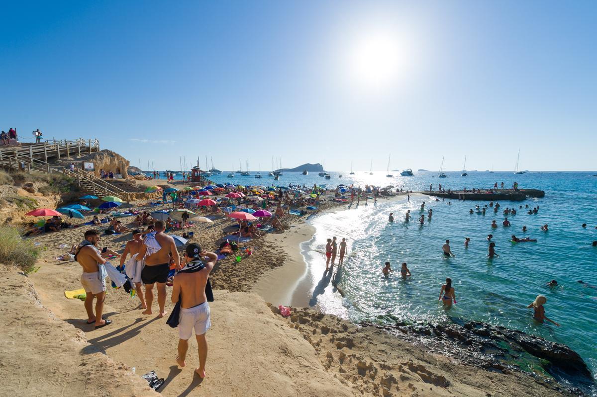 Cala Bassa está rodeada por un bosque de viejas sabinas de troncos retorcidos y presume de aguas azul turquesa y suave arena dorada.