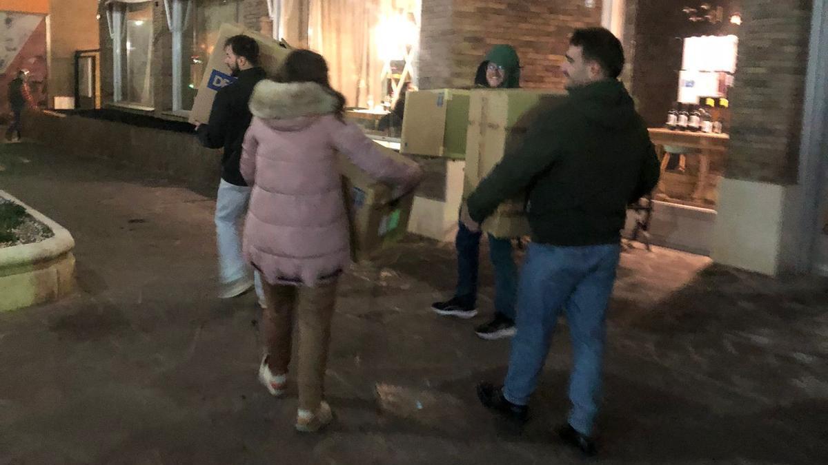 Varios de los voluntarios, este viernes por la noche, con el material para entregar.