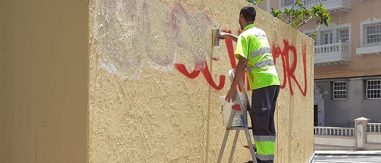 Un operario municipal de Santa Cruz elimina un grafiti realizado en la ciudad.