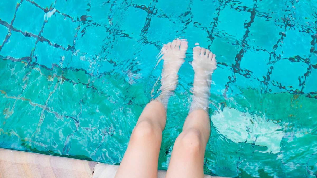 Una persona es remulla els peus en una piscina, en una imatge d'arxiu.