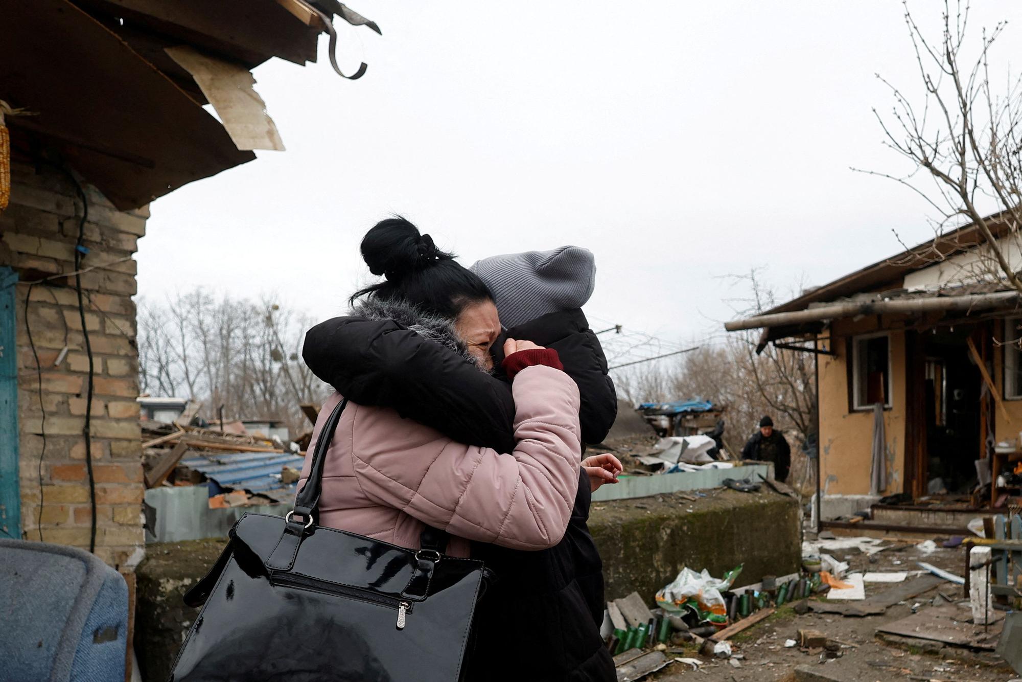 Dos residentes de Kiev se abrazan tras la caída de un misil ruso.