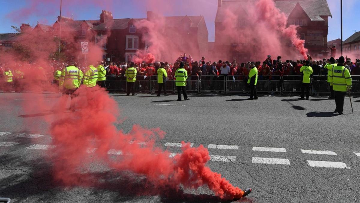 Los seguidores del Liverpool dejan bombas de humo rojo mientras esperan la llegada del autobús del equipo antes del partido de la Premier League entre el Liverpool y el Wolverhampton Wanderers en Anfield en Liverpool.