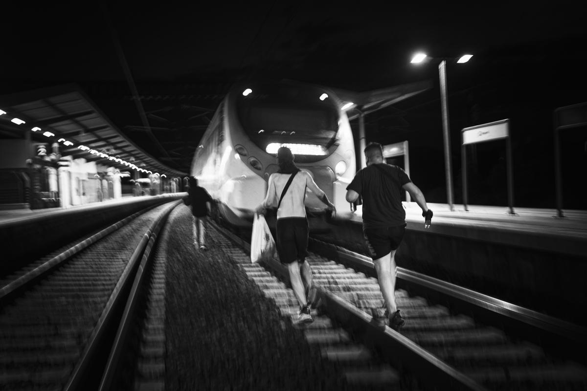 De izquierda a derecha, R. P. y C. corren tras el tren que se marchaba de la estación a media acción. Después de accionar el frenado de emergencia el conductor debe desbloquearlo antes de poder poner en marcha de nuevo el tren.