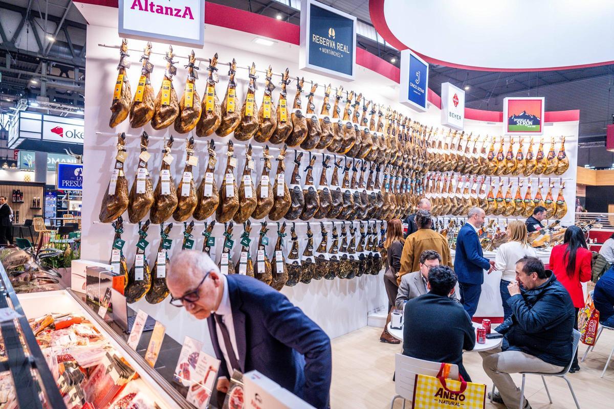 Un visitante observa un surtido de jamones expuesto en el salón Alimentaria Hostelco de la Fira de Barcelona.