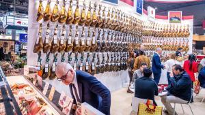 Un visitante observa un surtido de jamones expuesto en el salón Alimentaria Hostelco de la Fira de Barcelona.