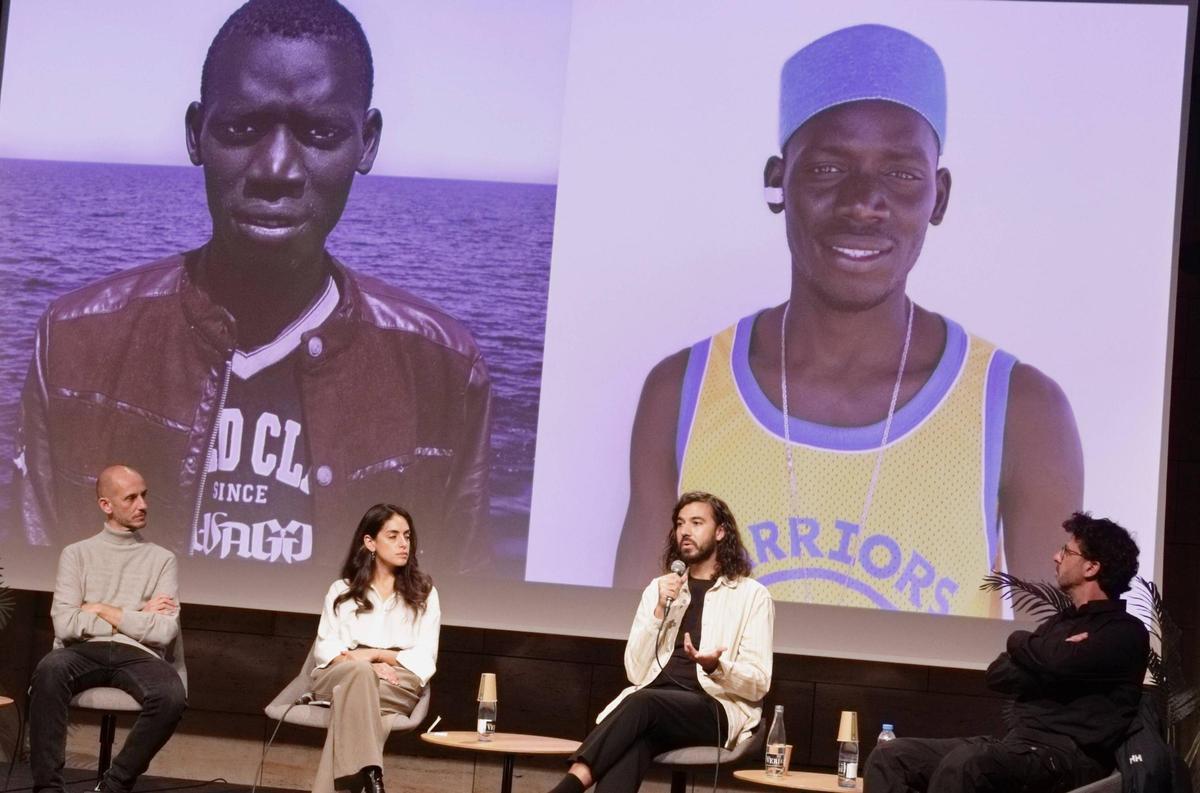 César Dezfuli, con el micro y ante dos retratos de su trabajo 'Pasajeros', en la presentación de World Press Photo en el CCCB.