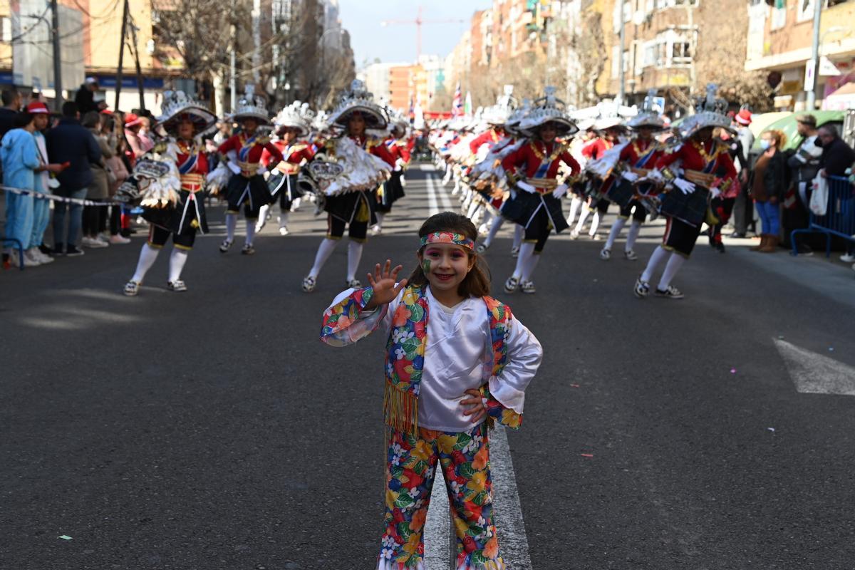 Una niña saluda con la mano delante de la comparsa Moracantana, ganadora del primer premio del desfile de San Roque.