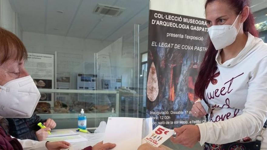 Una vecina de Alcalà de Xivert recoge el bono de 5 euros para gastar en el comercio local que le corresponde solo por estar empadronada y ser mayor de edad.