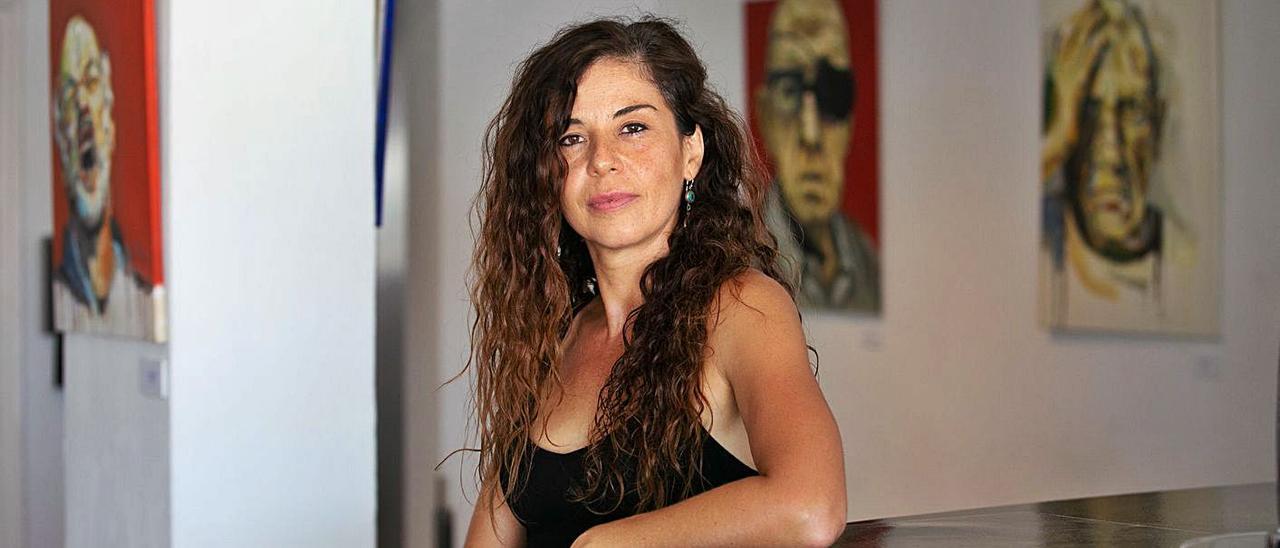 Ana Blanco García, ‘Tierra’, posa junto a algunos de los retratos de su primera exposición en la isla.  |  VICENT MARÍ