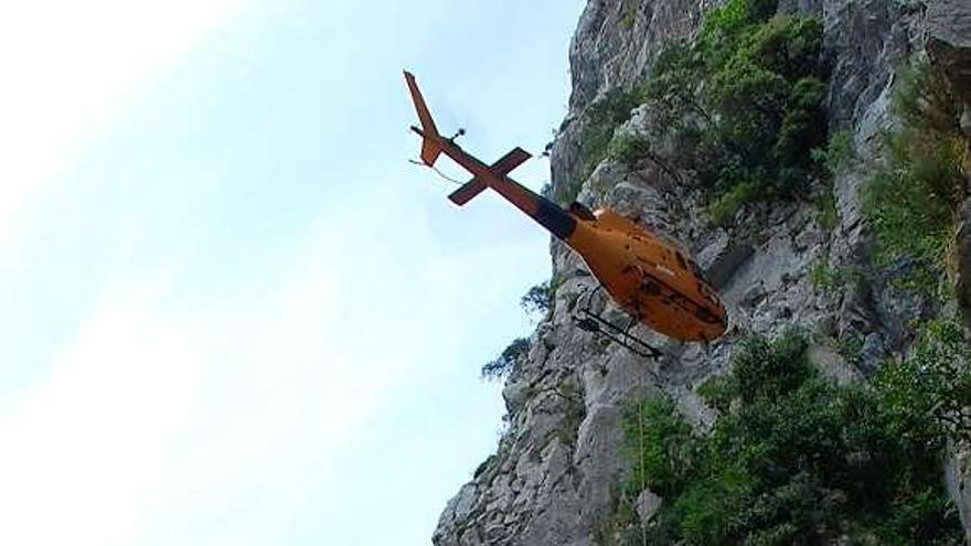 El helicóptero deposita un compresor en la senda del Cares.
