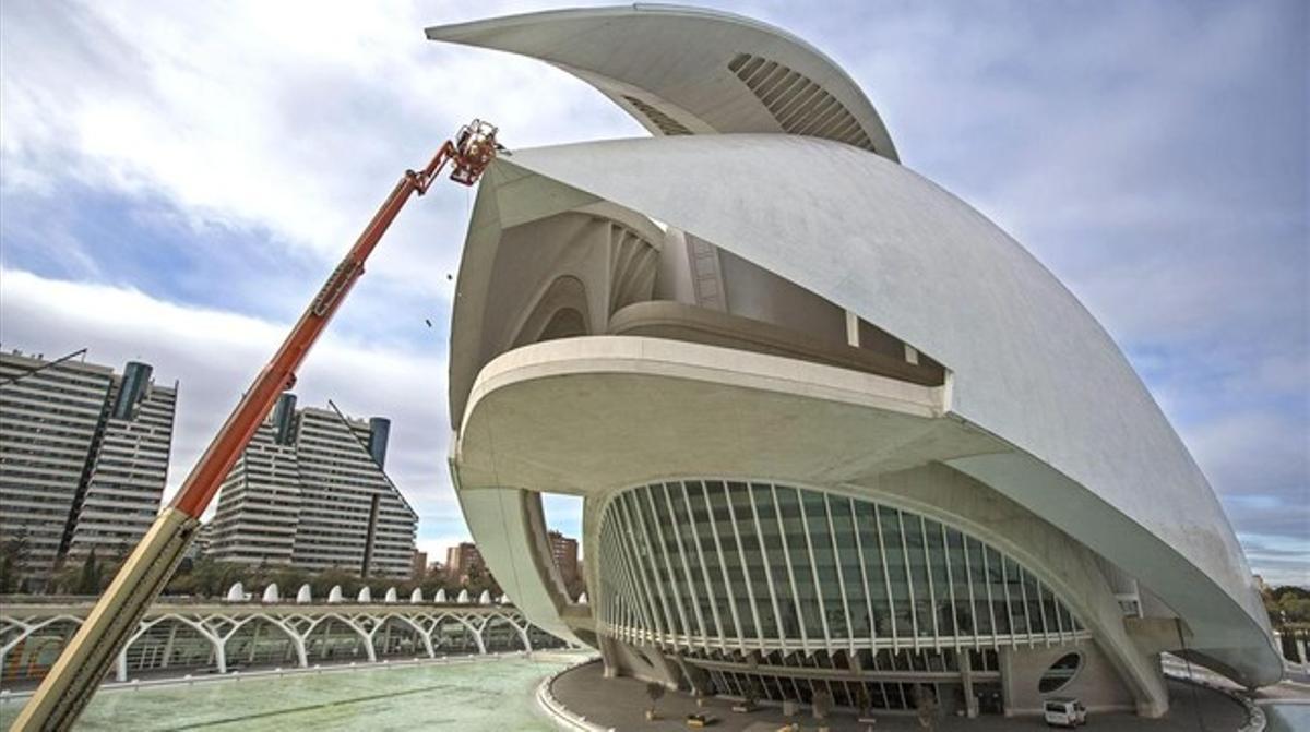 Dos operaris treballen, des d’una plataforma elevadora, en la retirada del revestiment de la coberta del Palau de les Arts de València després dels despreniments de desembre passat que han obligat a tancar l’auditori d’òpera.