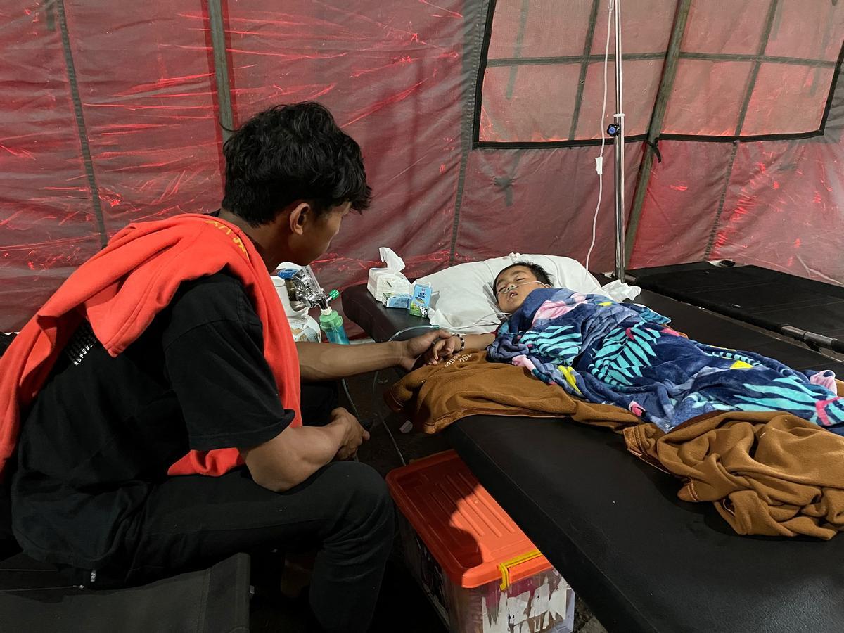 Salman Alfarisi, de 22 años, se sienta junto a su hermano pequeño Azka, de seis años, en una tienda de campaña de emergencia fuera del hospital en Cianjur, Indonesia. Salman Alfarisi, de 22 años, se sienta junto a su hermano pequeño Azka, de seis años, en una tienda de campaña de emergencia fuera del hospital en Cianjur, Indonesia.