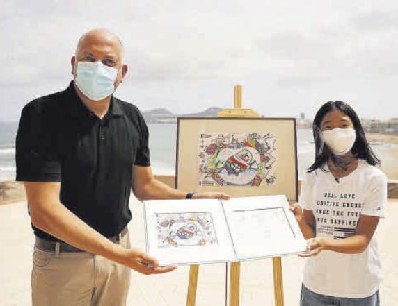 Ismael Alemán y la ganadora, Se Eun Hong, muestran el dibujo premiado.