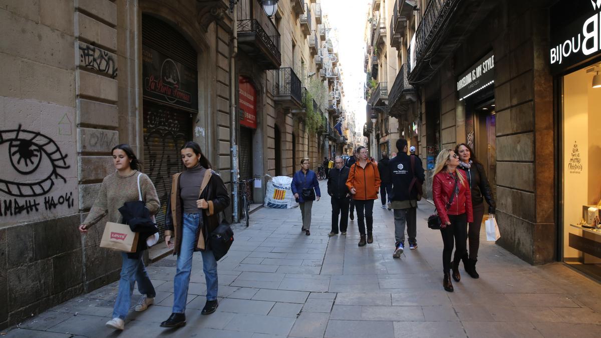 Alternancia de negocios abiertos y persianas bajadas, junto con obras de reforma, en la calle de Portaferrissa.