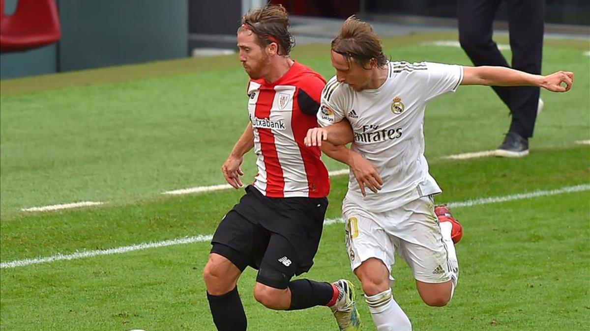 Muniain pugna con Modric por un balón en el centro del campo