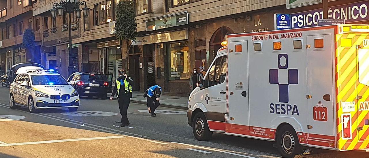 La ambulancia, con el herido en el interior, en el lugar del accidente, mientras los agentes de la Policía Local recogen pruebas y objetos personales del atropellado. | LNE