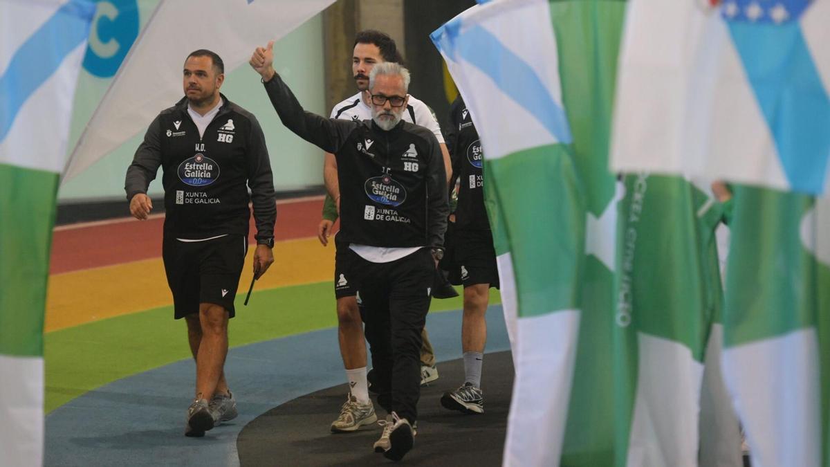 Juan Copa y su cuerpo técnico saludan a la afición entre banderas del Liceo y de Galicia en la previa de un encuentro en Riazor.
