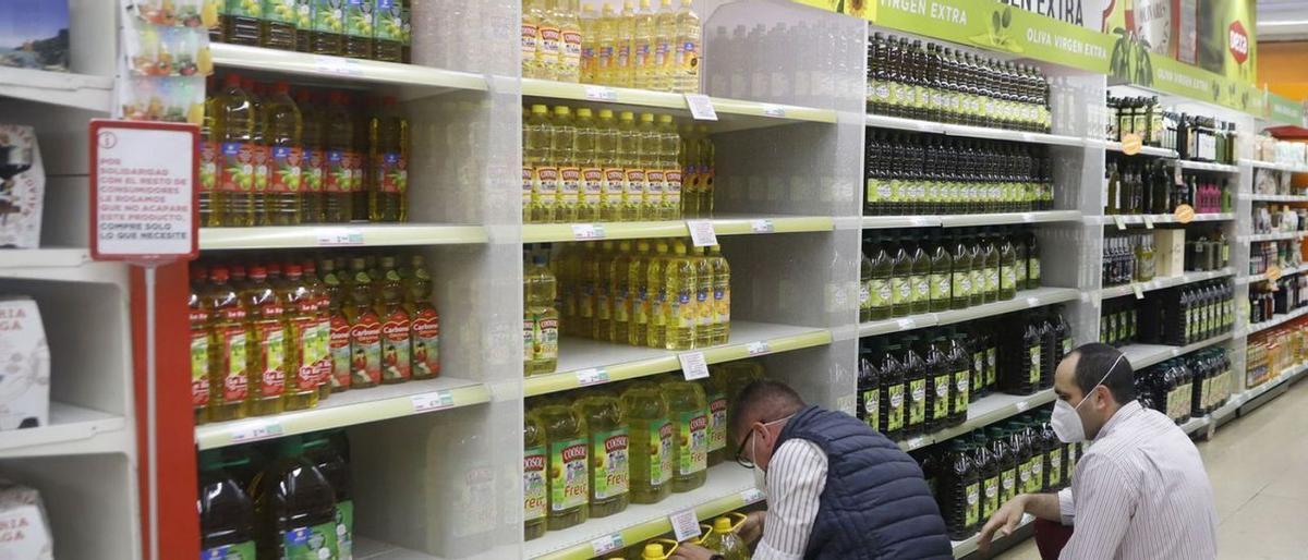 Profesionales trabajan con el aceite en un supermercado.