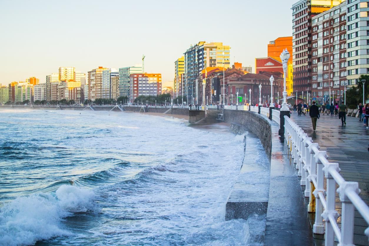 Olas salpicando la pared en la playa de San Lorenzo en Gijón.