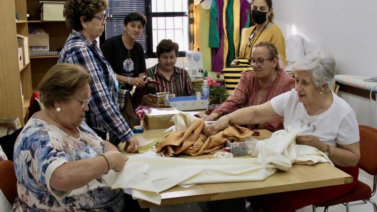 Mujeres voluntarias confeccionando los trajes para la representación teatral.