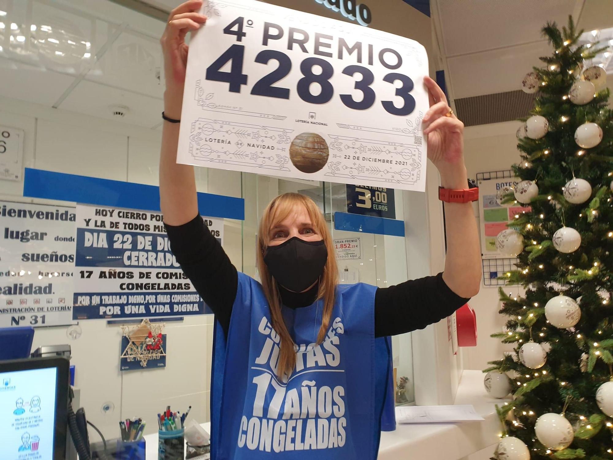 Raquel Rego, de la administración de loterías de El Corte Inglés, posa con uno de los cuartos premios de los que vendió 10 décimos.