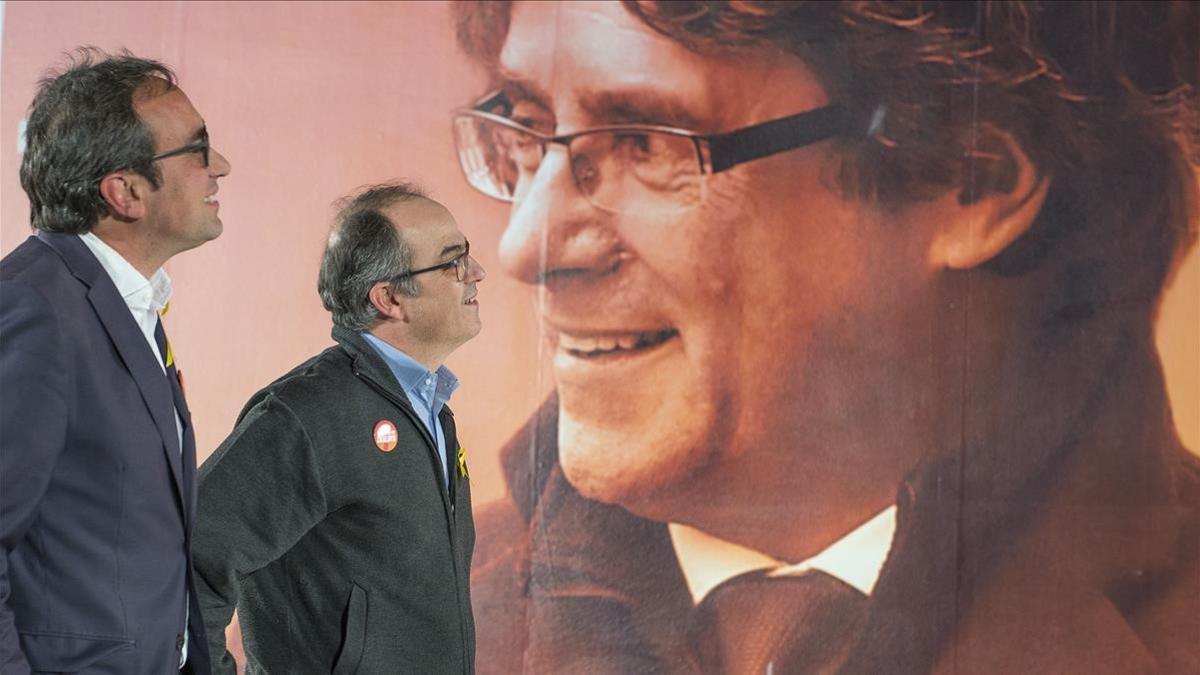 Jordi Turull y Josep Rull ante el cartel electoral de Carles Puigdemont